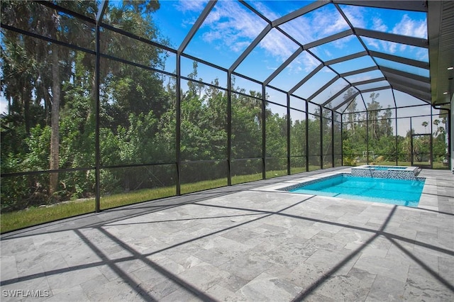 view of pool with glass enclosure, an in ground hot tub, and a patio area