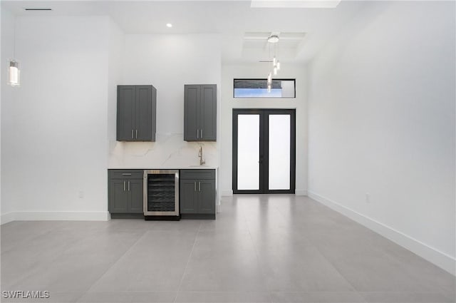 foyer featuring french doors, beverage cooler, a high ceiling, and sink