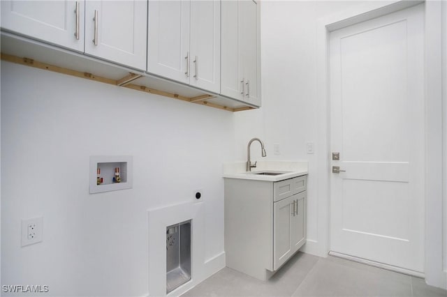 clothes washing area featuring electric dryer hookup, hookup for a washing machine, cabinets, and sink