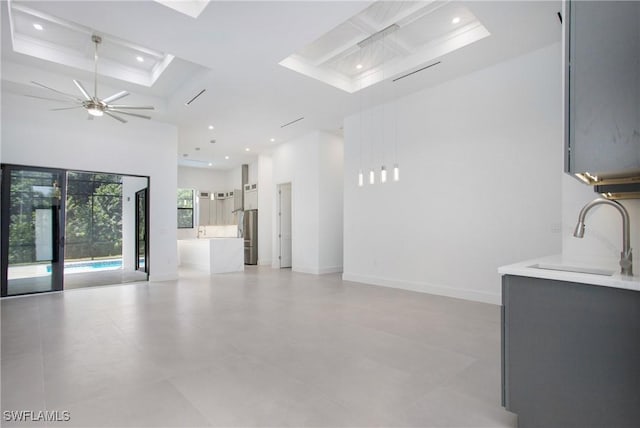 interior space featuring ceiling fan, sink, and a high ceiling