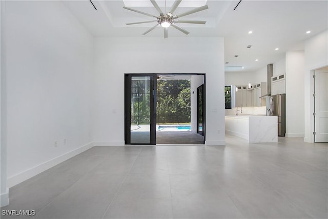 spare room with a high ceiling, ceiling fan, and sink