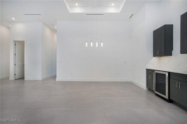 unfurnished living room featuring a raised ceiling and wine cooler