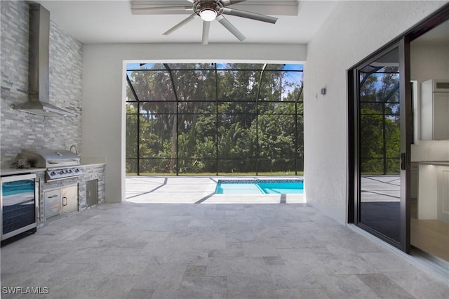 exterior space with grilling area, wine cooler, ceiling fan, a lanai, and exterior kitchen