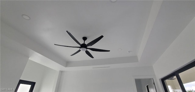 room details featuring ceiling fan and a tray ceiling