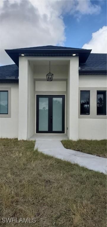 doorway to property with a lawn