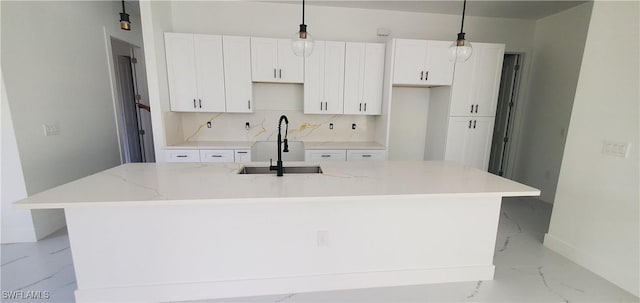 kitchen with a center island with sink, pendant lighting, and sink