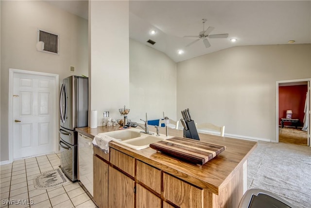 kitchen featuring stainless steel refrigerator, ceiling fan, dishwasher, sink, and light tile patterned flooring