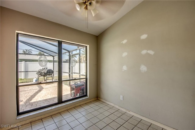 tiled spare room featuring ceiling fan and vaulted ceiling