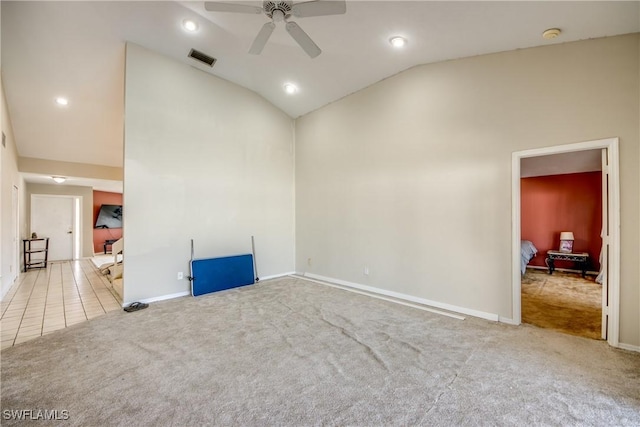 empty room featuring light carpet, ceiling fan, and vaulted ceiling