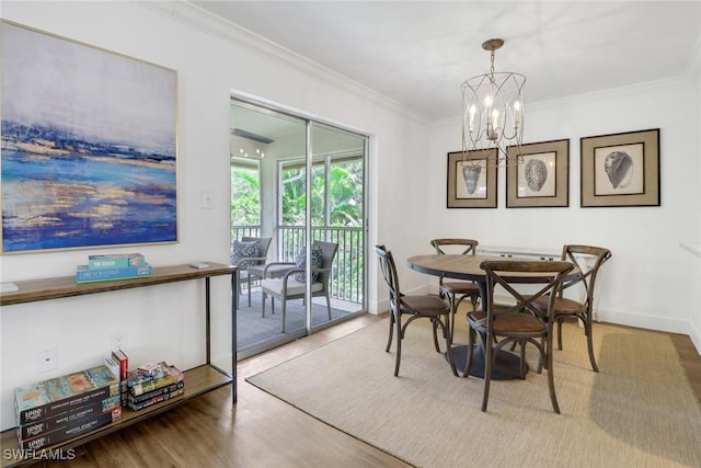 dining room with ornamental molding, hardwood / wood-style floors, and a chandelier