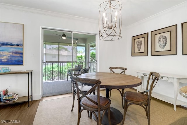 dining room with ornamental molding, wood-type flooring, and an inviting chandelier