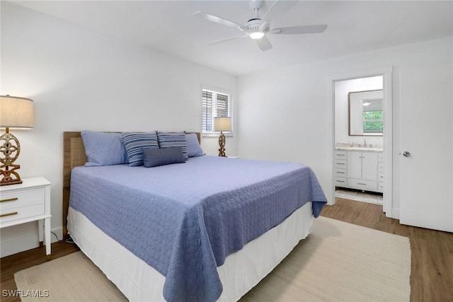 bedroom with hardwood / wood-style flooring, ceiling fan, sink, and ensuite bath