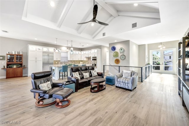 living room with high vaulted ceiling, french doors, beamed ceiling, and light hardwood / wood-style flooring