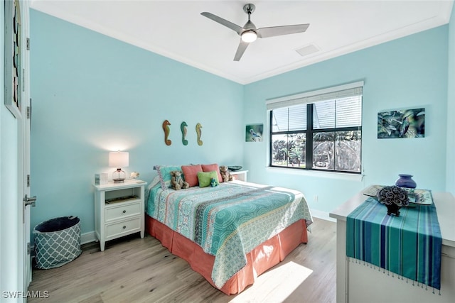 bedroom featuring ceiling fan, crown molding, and light hardwood / wood-style floors