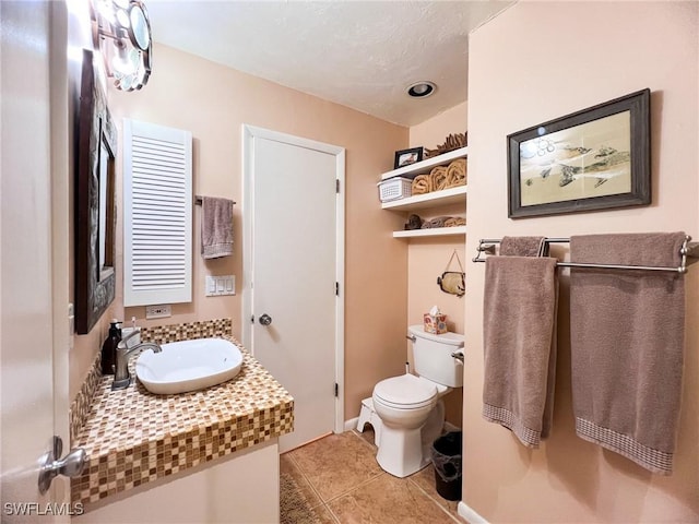 bathroom with tile patterned flooring, vanity, and toilet