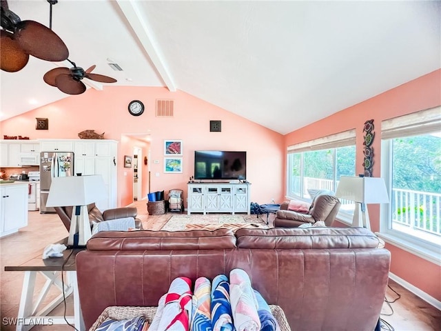 living room with a wealth of natural light, lofted ceiling with beams, and ceiling fan