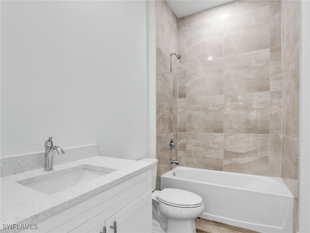 full bathroom with vanity, tiled shower / bath combo, and toilet