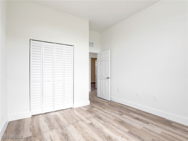 unfurnished bedroom featuring a closet and light hardwood / wood-style floors