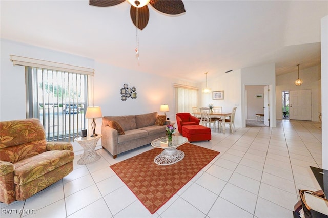 living room with ceiling fan, light tile patterned floors, and lofted ceiling