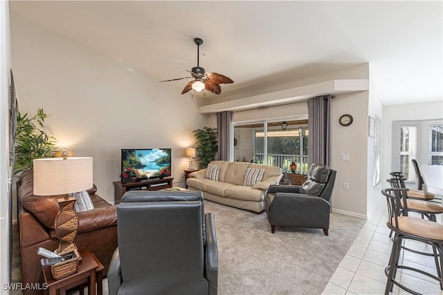 living area with light tile patterned floors, ceiling fan, and baseboards