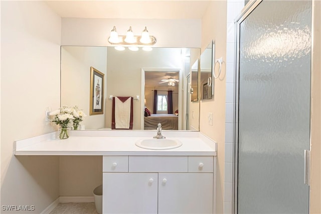 ensuite bathroom featuring vanity, connected bathroom, a shower with shower door, and baseboards