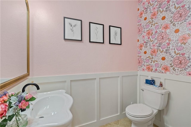 2669 Citrus St, Naples, FL 34120 - half bathroom with a decorative wall, toilet, wainscoting, and a sink