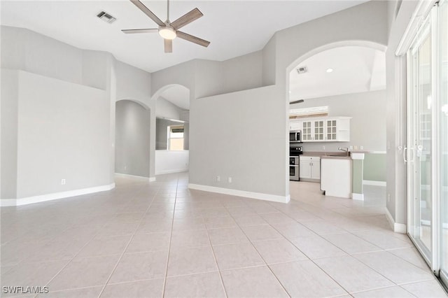 unfurnished room with sink, ceiling fan, and light tile patterned flooring