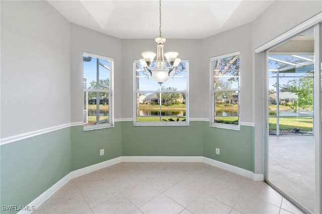 unfurnished dining area with tile patterned floors and a chandelier