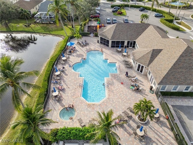 pool featuring a patio, a water view, and a sunroom