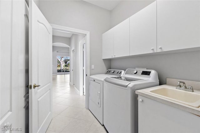 laundry room with light tile patterned flooring, cabinets, independent washer and dryer, and sink