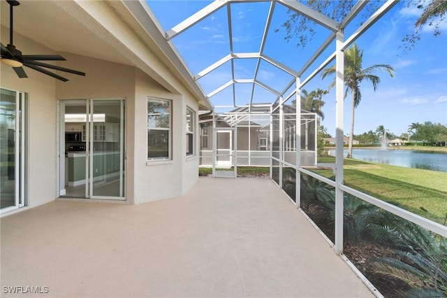 unfurnished sunroom featuring ceiling fan, a water view, and lofted ceiling