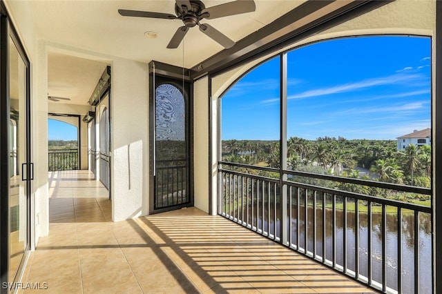 balcony with a water view and ceiling fan