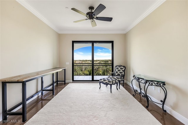 living area featuring dark hardwood / wood-style flooring, ornamental molding, and ceiling fan