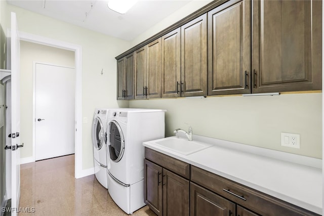 clothes washing area featuring cabinets, washer and dryer, and sink