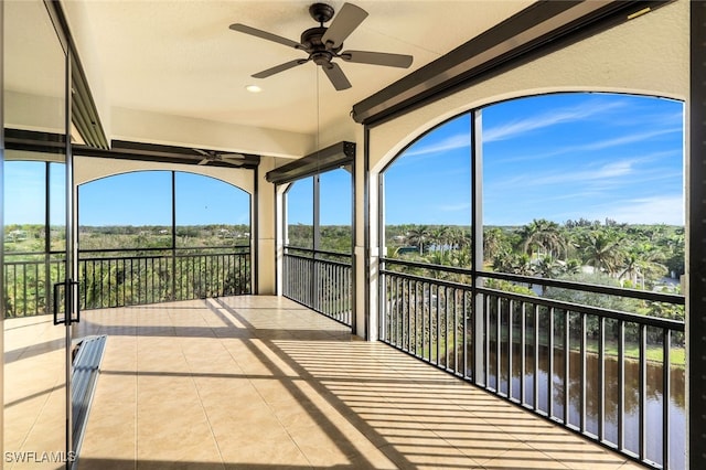 unfurnished sunroom with a ceiling fan