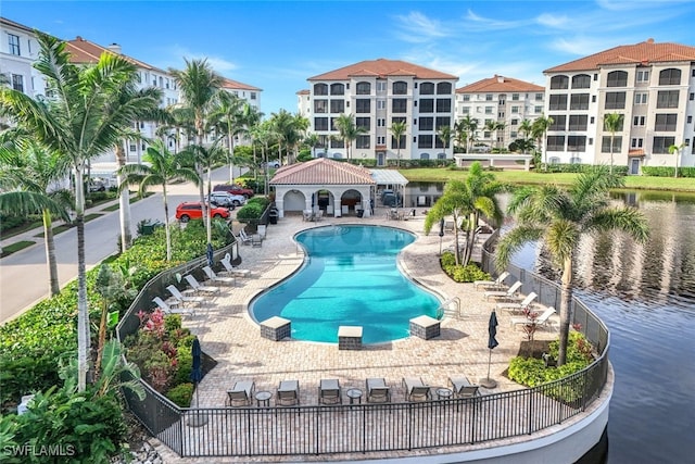 view of pool featuring a water view and a patio area