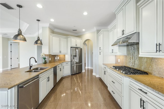 kitchen with appliances with stainless steel finishes, pendant lighting, sink, white cabinets, and light stone countertops