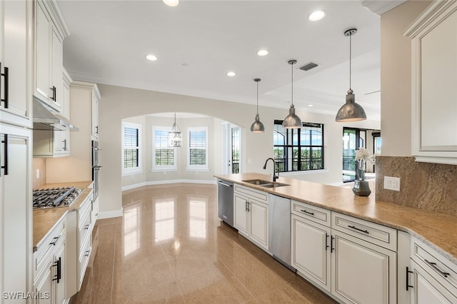 kitchen featuring appliances with stainless steel finishes, sink, a wealth of natural light, and decorative light fixtures