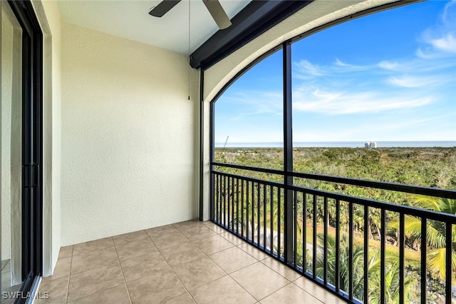 balcony with ceiling fan and a water view