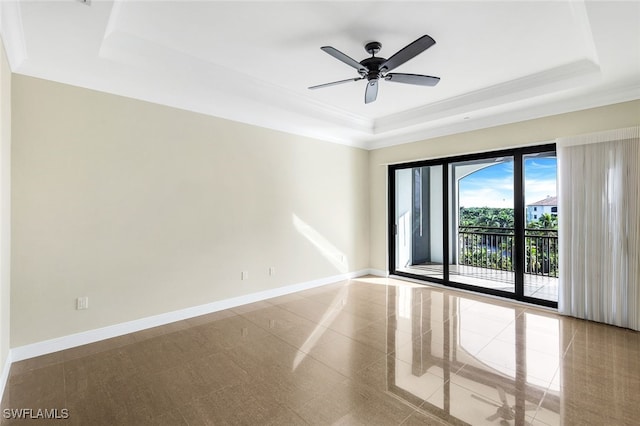 spare room featuring ornamental molding, a raised ceiling, and ceiling fan