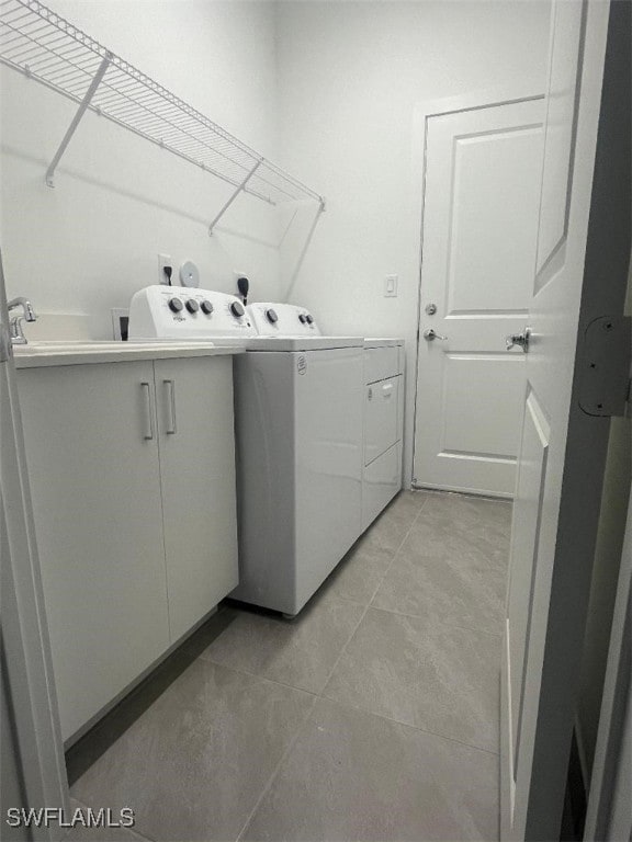 washroom with washer and clothes dryer and light tile patterned flooring