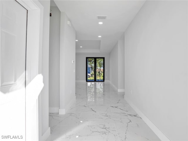 hallway with marble finish floor, baseboards, and visible vents