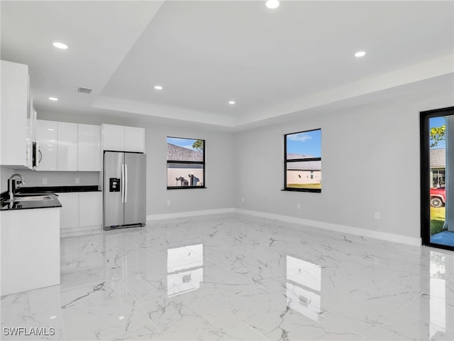 kitchen with recessed lighting, white cabinetry, appliances with stainless steel finishes, dark countertops, and a raised ceiling