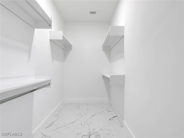 walk in closet with marble finish floor and visible vents