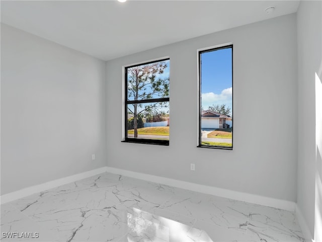 1423 NW 20th Ter, Cape Coral, FL 33993 - unfurnished room featuring baseboards, marble look tiles, and a smoke detector