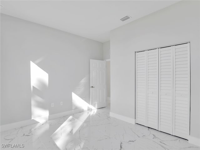 unfurnished bedroom featuring marble finish floor, visible vents, and baseboards