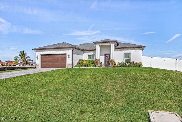 prairie-style house featuring a garage and a front lawn