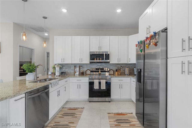 kitchen featuring white cabinetry, light stone countertops, decorative light fixtures, and appliances with stainless steel finishes