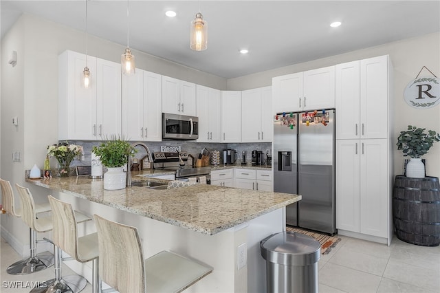 kitchen with kitchen peninsula, white cabinets, and stainless steel appliances