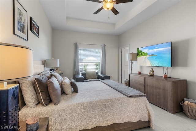 bedroom with ceiling fan and a tray ceiling